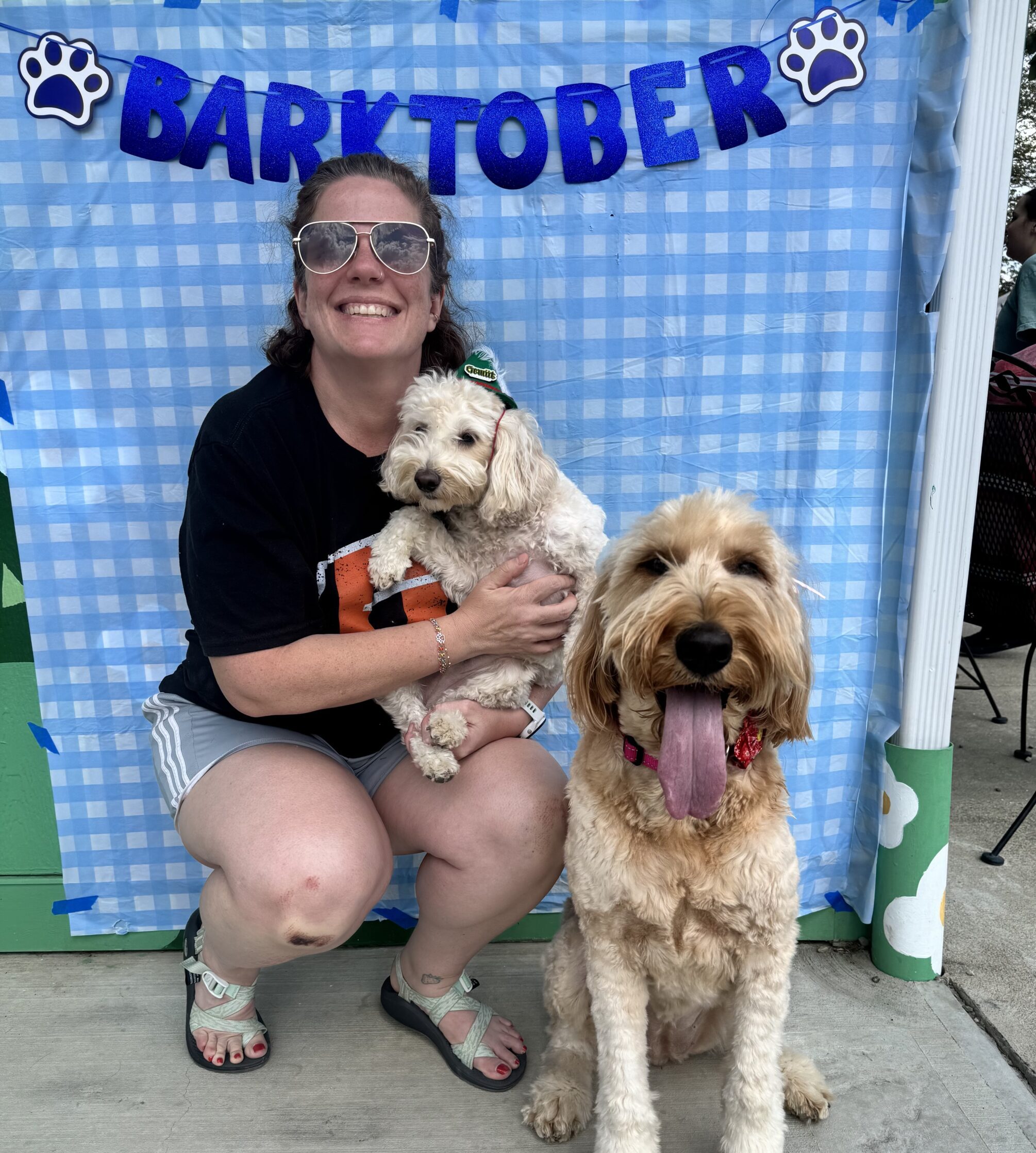 Dr. Heather Yardley smiling at a Barktober event holding two dogs